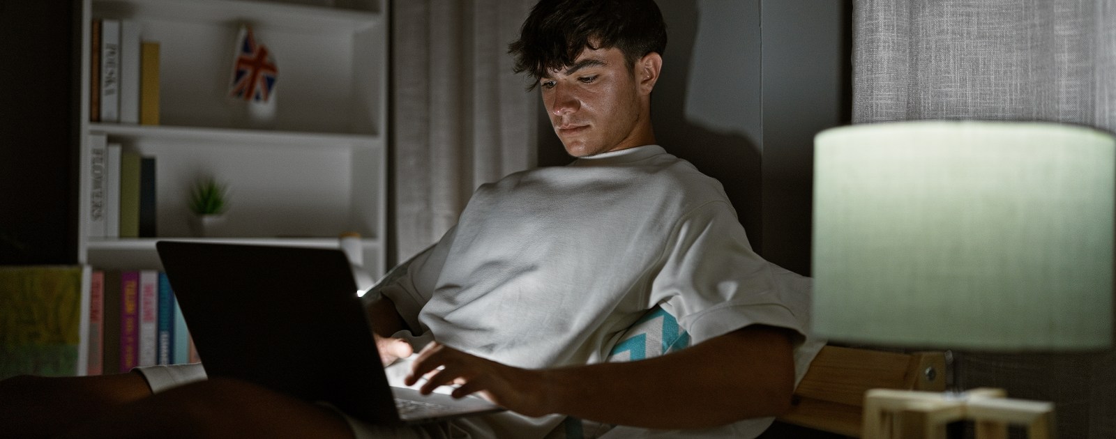 adolescente ao computador na cama