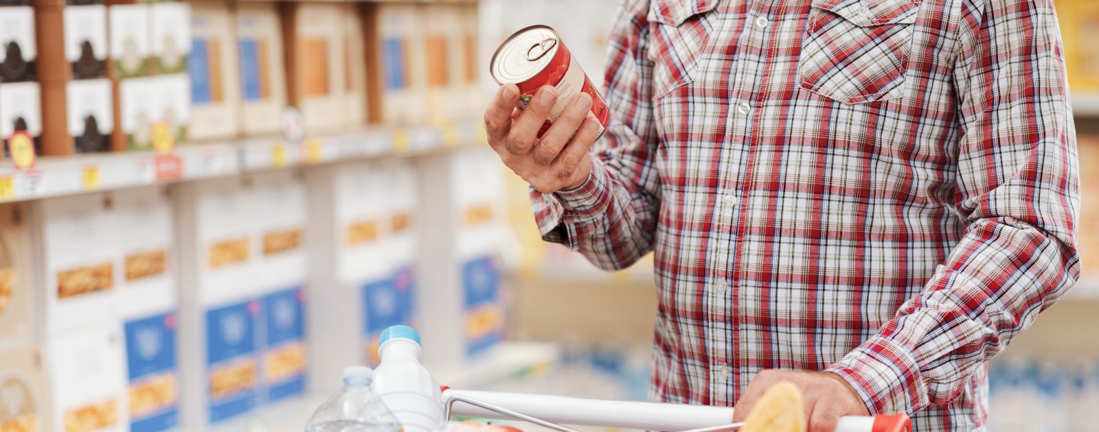 homem a ler rótulo de lata de tomates