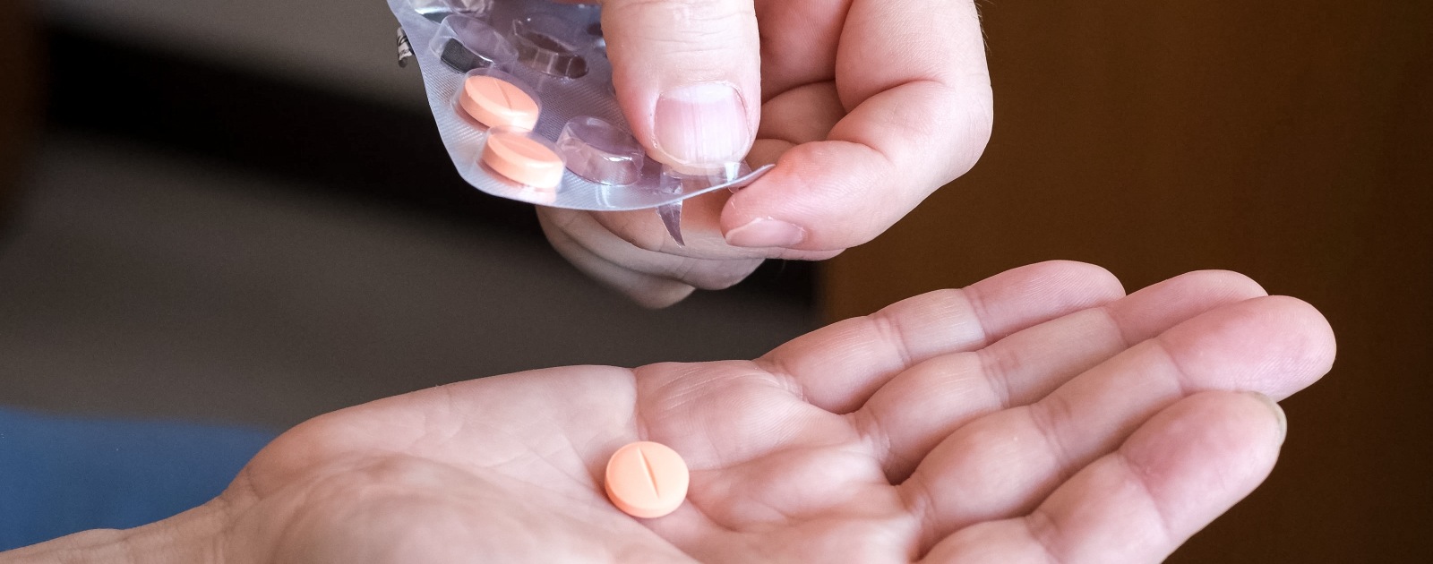 homem a tirar comprimido do pacote