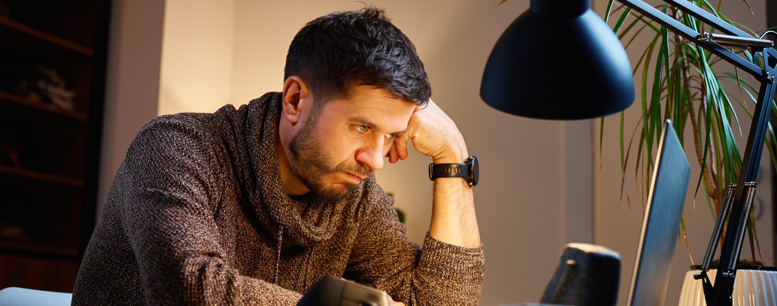 homem cansado sentado à secretária