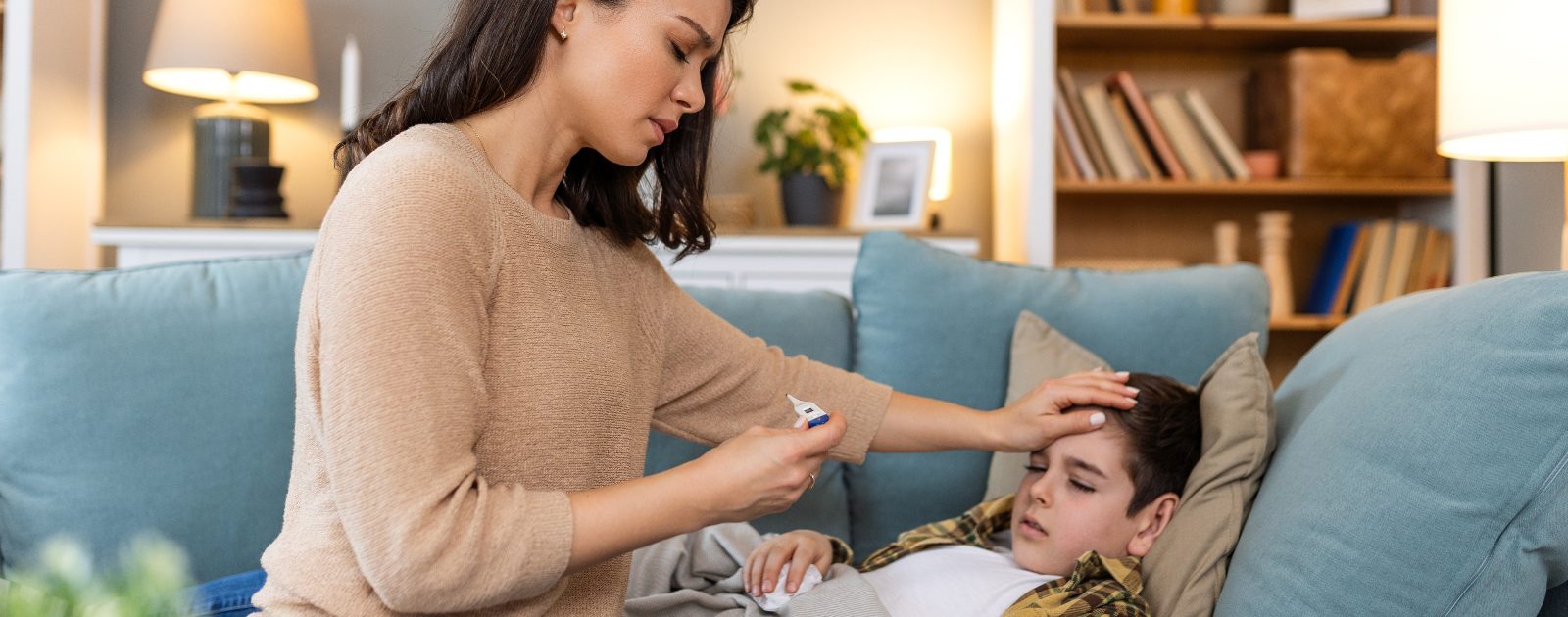 mãe a medir a febre do filho