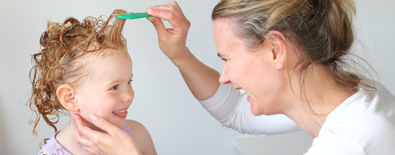 mãe a remover piolhos do cabelo da filha