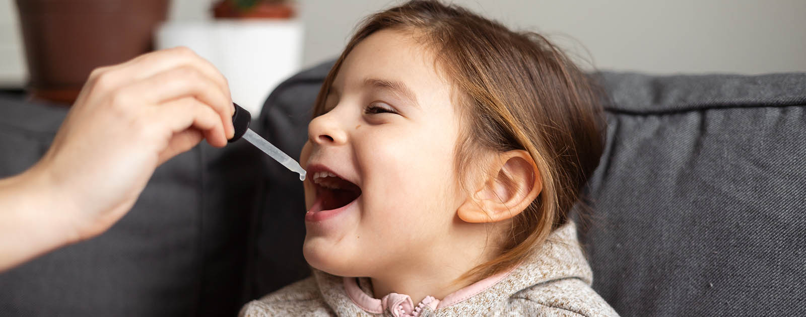 mãe dá medicamento homeopático à filha