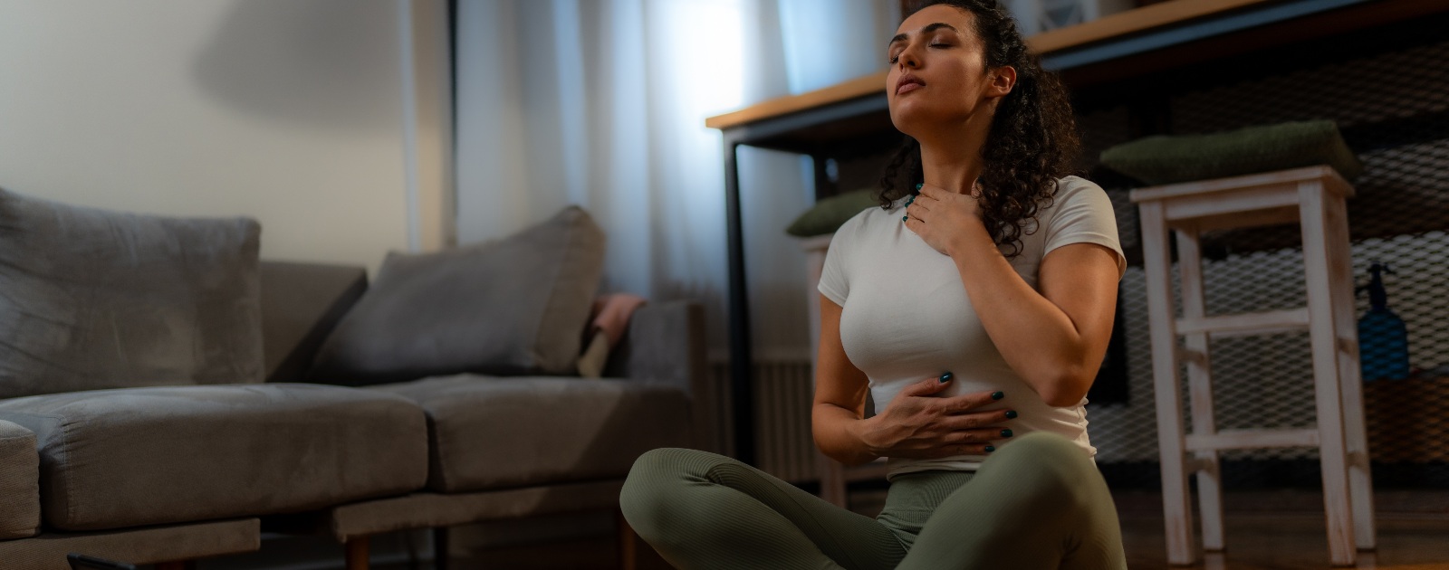 mulher a fazer ioga em casa à noite
