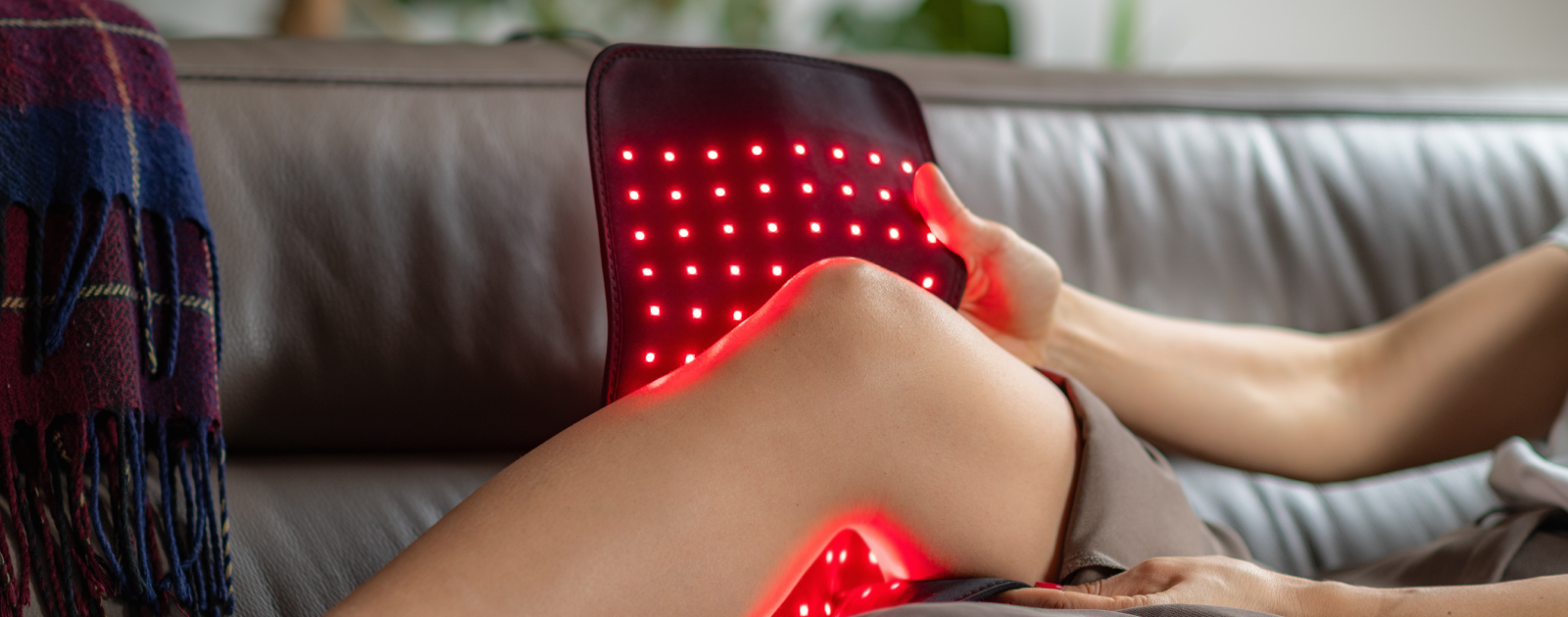 mulher a usar terapia da luz vermelha no joelho