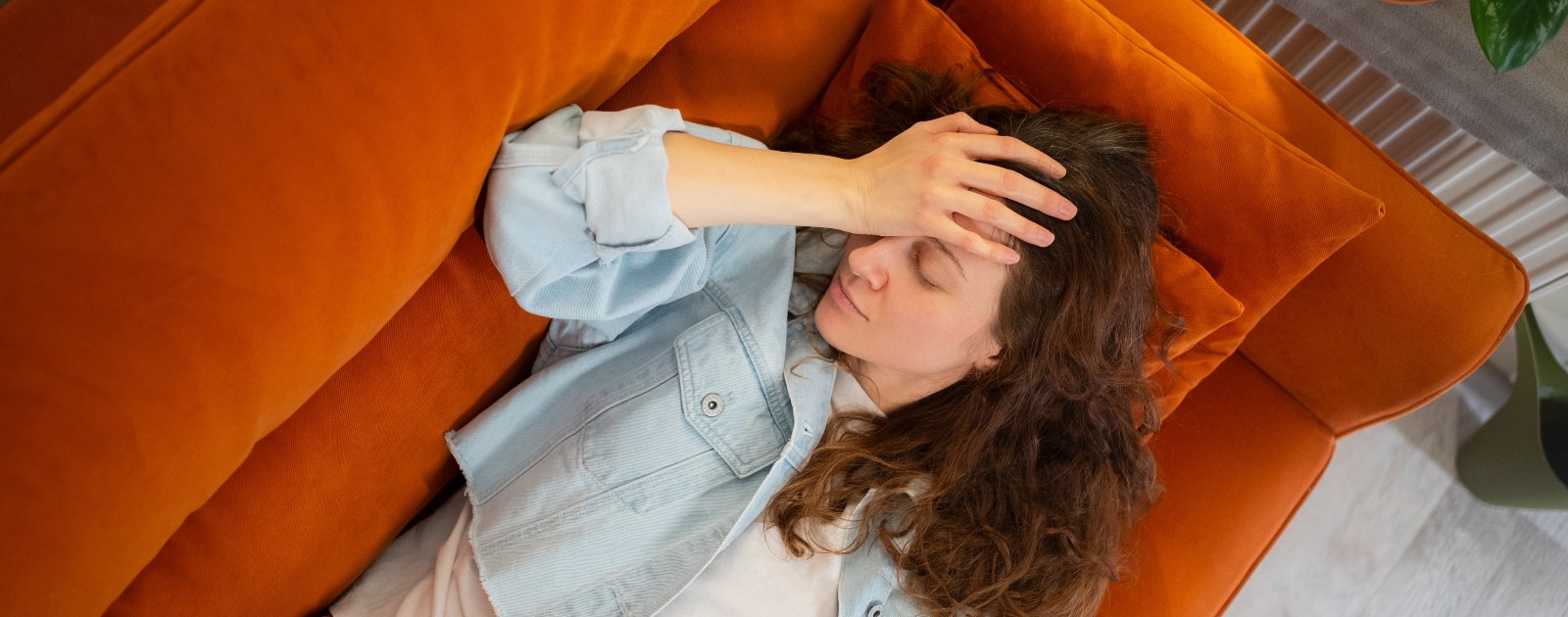 mulher deitada no sofá com ar stressado