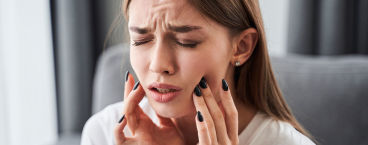 mulher com dor intensa causada pela alveolite dentária