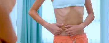 rapariga com anorexia nervosa a tocar na barriga