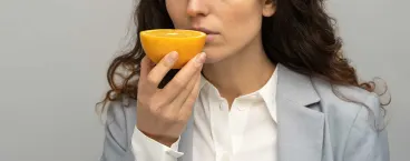 mulher a tentar cheirar uma laranja