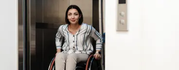 mulher de cadeira de rodas a andar de elevador