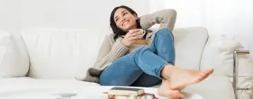 rapariga relaxa no sofá enquanto bebe chá