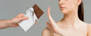 rapariga a comer chocolate com borbulhas na cara