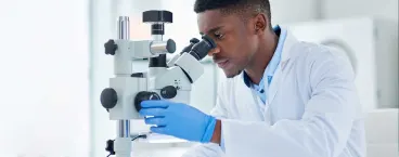 médico a analisar resultados de citologia no microscópio