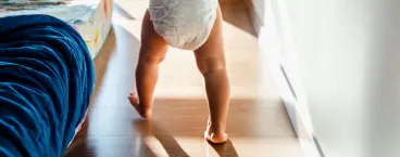bebé de fralda a andar