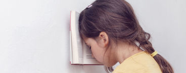 menina com cabeça encostada a livro
