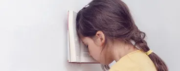 menina com cabeça encostada a livro