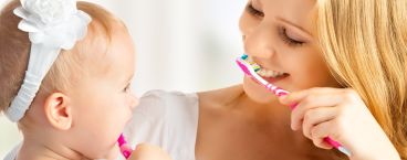 mãe ensina filha a lavar os dentes