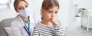 menina com tosse a ser auscultada por médica