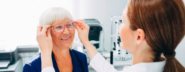 oftalmologista coloca óculos em senhora com miopia