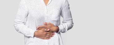 mulher a pressionar a região abdominal 