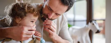 pai a usar aspirador nasal na filha para tratar a tosse