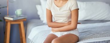 mulher sentada na cama com braços cruzados