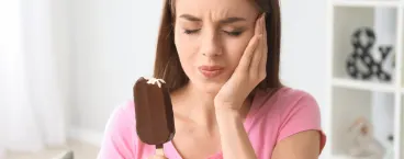 rapariga sente dor nos dentes ao comer um gelado