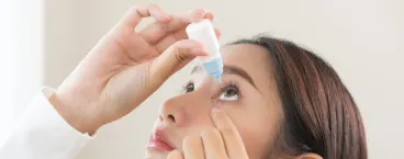 rapariga a colocar gotas nos olhos