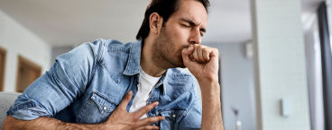 homem com mão no peito a tossir