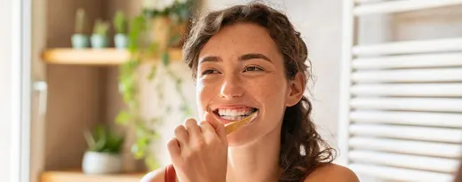 rapariga a escovar os dentes com escova manual