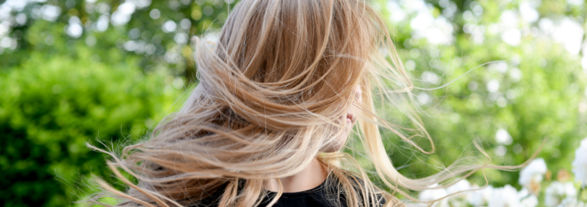 Imagem de uma mulher com os cabelos loiros ao vento