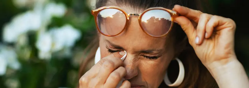 mulher com os olhos a lacrimejar