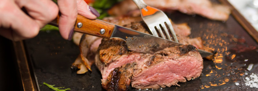 mulher a fatiar um bife