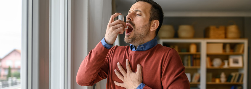 homem a usar inalador para controlar crise asmática