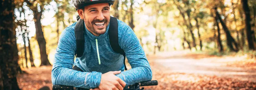 rapaz a sorrir enquanto anda de bicicleta