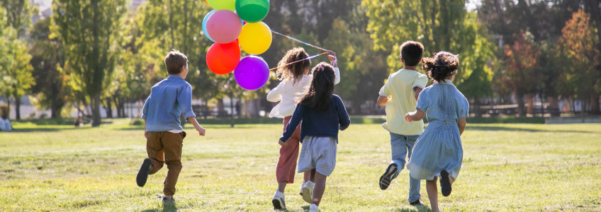 Crianças a correr com balões