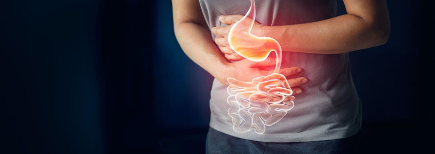mulher sentada com dores abdominais a conversar com o médico