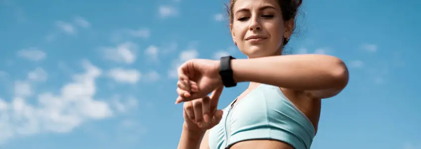 mulher olha para smartwatch enquanto se exercita