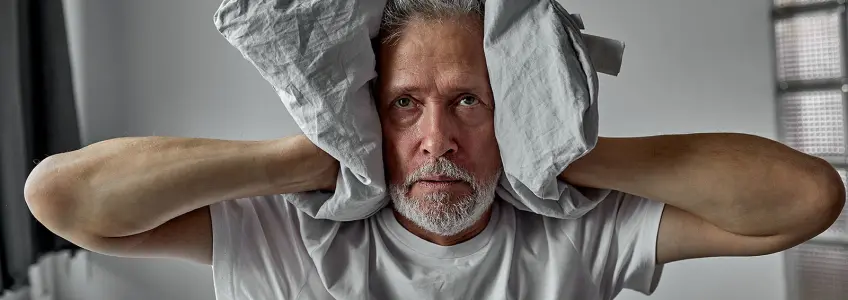 homem tapa os ouvidos durante um episódio de esquizofrenia