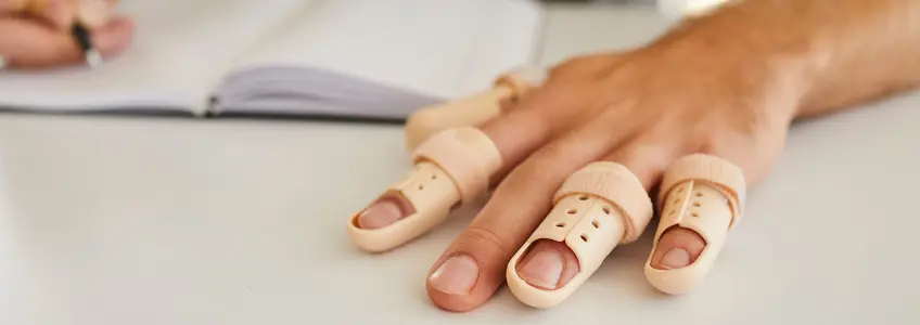 homem a usar talas para tratar o dedo em gatilho