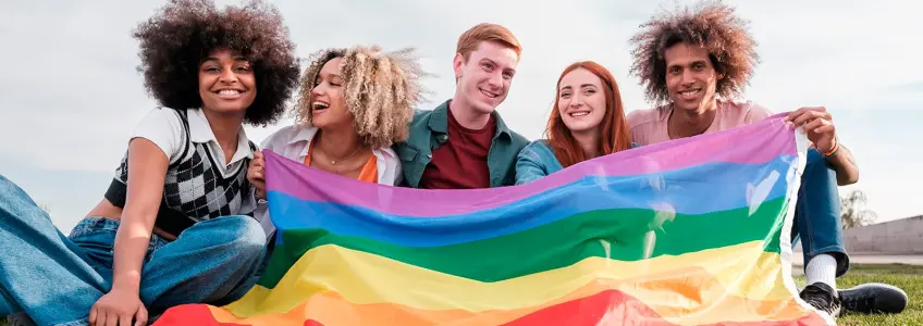 grupo de jovens a segurar a bandeira LGBT+