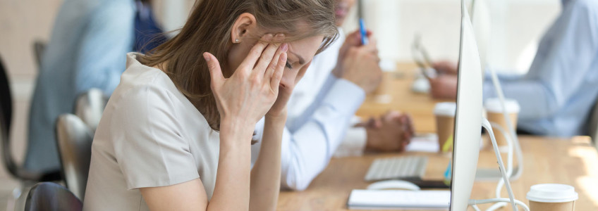 senhora com sinais de stress durante o trabalho