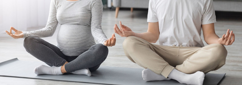 mãe grávida e pai juntos a praticar yoga