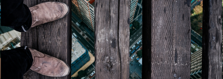 pessoa em cima de uma ponte de madeira com vertigens
