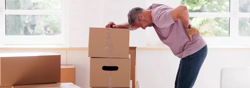 homem sente dor após carregar caixas