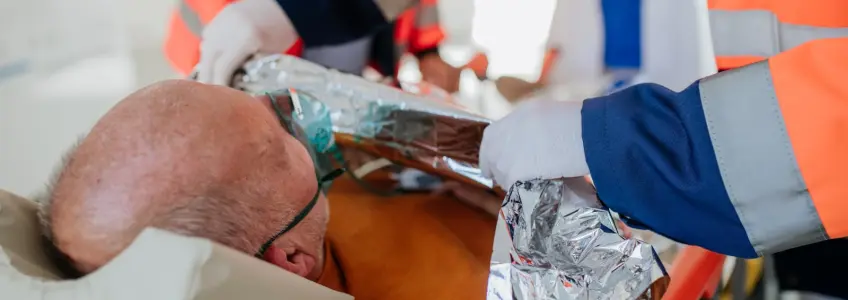 paramédico cobre idoso com manta térmica