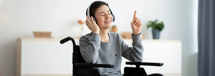 rapaz em cadeira de rodas sorri a ouvir música