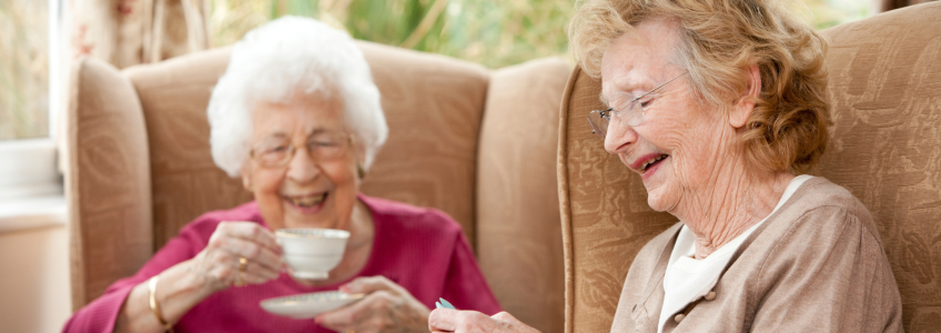 2 idosas a ter um encontro de amigas a tomar chá em casa