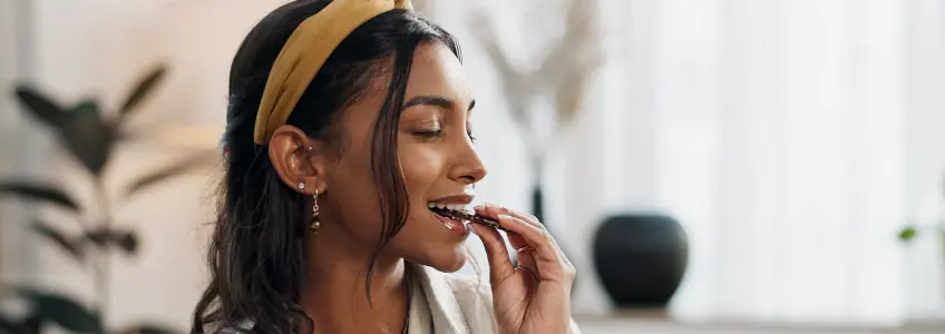 mulher a comer um pedaço de chocolate