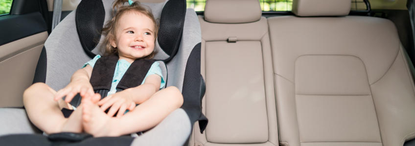 Criança sentada numa cadeirinha para criança num carro